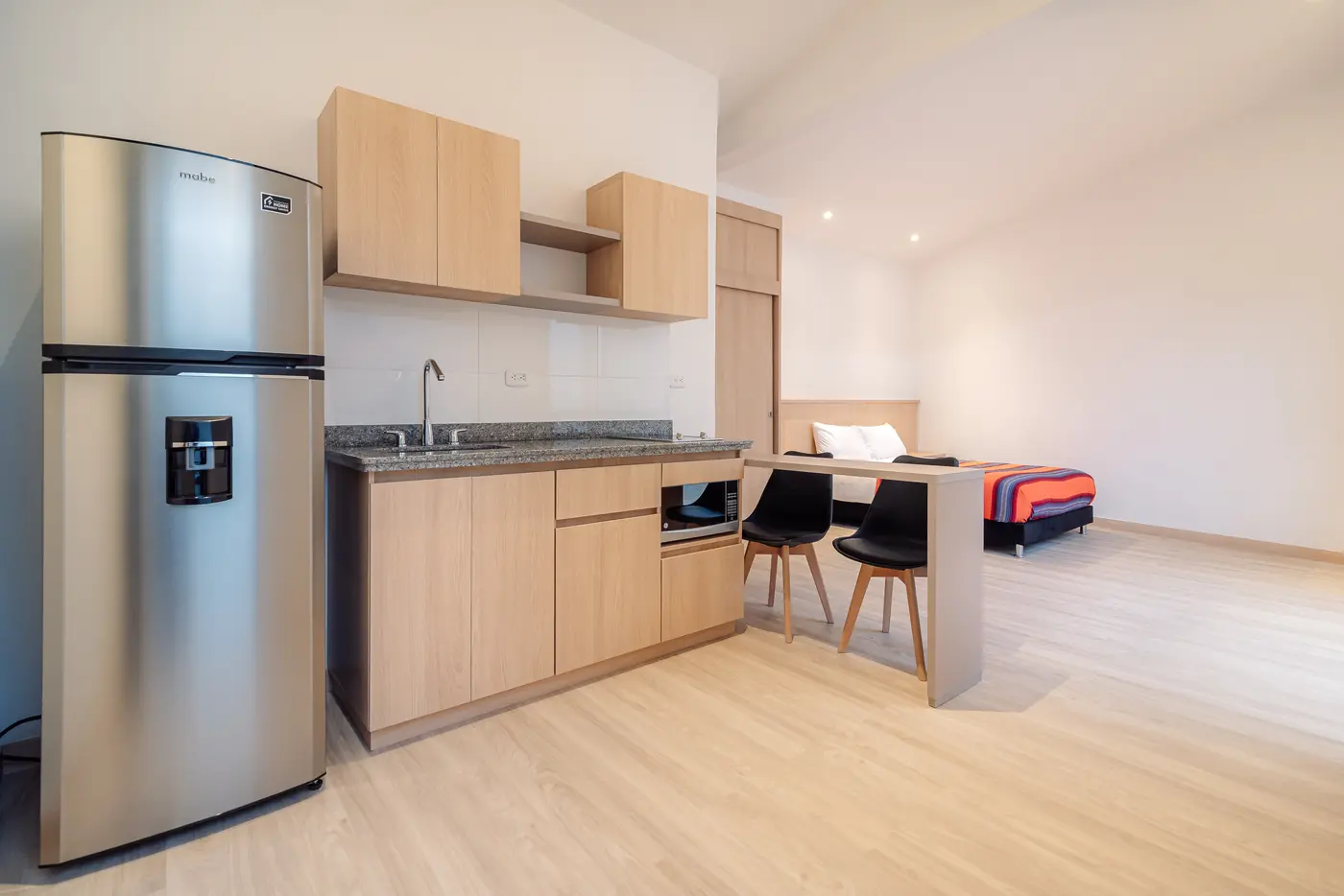 Cocina equipada del apartaestudio Clásica, con nevera, microondas y comedor