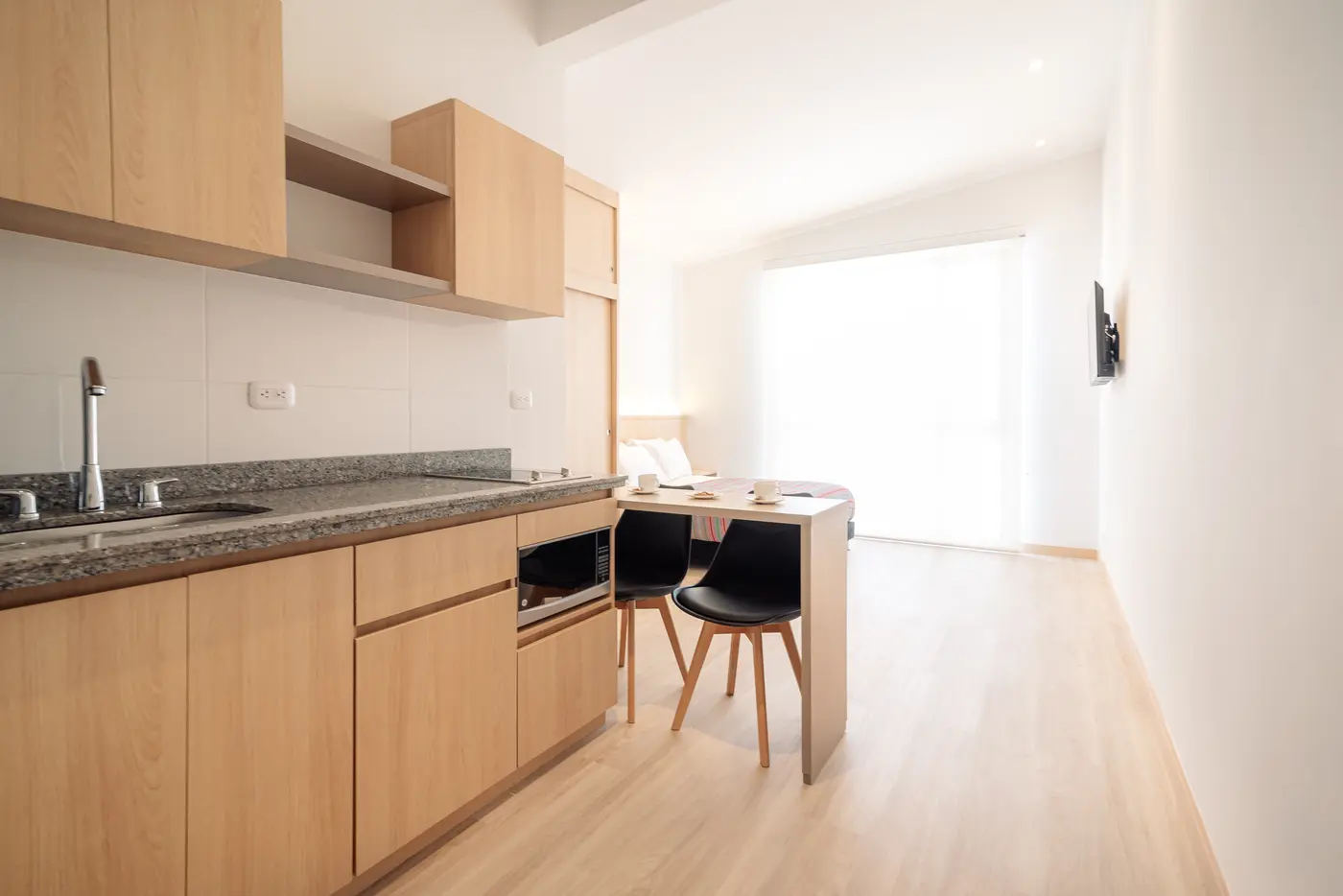 Cocina y comedor del apartaestudio Reserva junto al ventanal